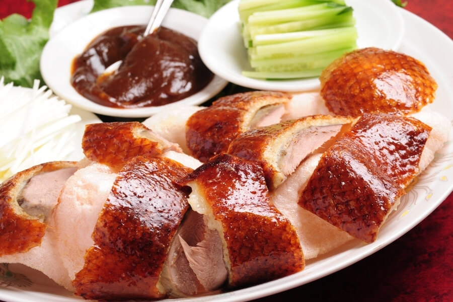 Peking duck with pancakes, scallions, cucumber, sweet bean sauce, traditional Chinese cuisine for travelers